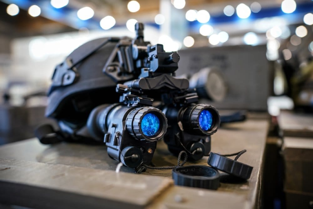 Close-up of advanced night vision goggles with blue lenses on a helmet.