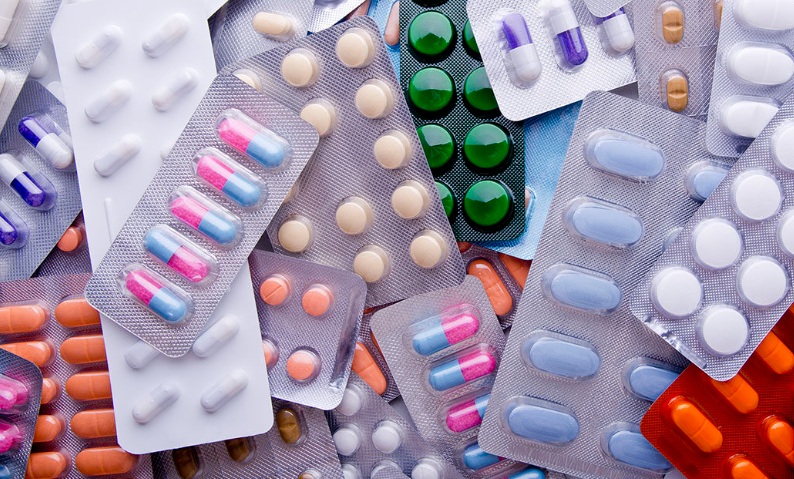 Various colorful pills and capsules in blister packs.